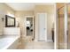 Bright bathroom with tub, shower, and vanity, with view into bedroom at 641 Weyburn Nw Dr, Concord, NC 28027