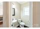 Cozy powder room with a pedestal sink, dark hardwood floors, and a decorative mirror at 641 Weyburn Nw Dr, Concord, NC 28027