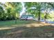 Spacious backyard featuring mature trees and a wooden deck, perfect for outdoor enjoyment at 676 Forest Nw St, Concord, NC 28025