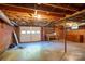 Unfinished basement with exposed ceiling, concrete floor, and garage door at 676 Forest Nw St, Concord, NC 28025