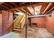 Unfinished basement with exposed red brick walls and a wooden staircase at 676 Forest Nw St, Concord, NC 28025