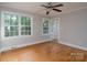 Sunny bedroom featuring multiple windows, hardwood floors, and a ceiling fan at 676 Forest Nw St, Concord, NC 28025
