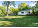 Charming single-story home with a well-manicured lawn and mature trees at 676 Forest Nw St, Concord, NC 28025