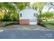 Rear view of the home showing a white garage door and a brick foundation at 676 Forest Nw St, Concord, NC 28025