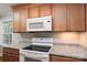 Kitchen features granite countertops, modern white appliances, and wooden cabinets at 676 Forest Nw St, Concord, NC 28025