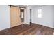 Bedroom featuring a sliding barn door, vinyl flooring, and a built-in closet at 678 Wagner St, Troutman, NC 28166