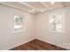 Cozy bedroom featuring hardwood floors, white trim and two bright windows at 678 Wagner St, Troutman, NC 28166
