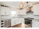 Bright kitchen features white cabinets, stainless steel appliances, granite counters, and stylish light fixtures at 678 Wagner St, Troutman, NC 28166