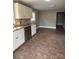 Well-lit kitchen with white cabinets, stainless steel dishwasher and adjoining tile flooring at 705 3Rd Nw Ave, Hickory, NC 28601