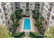 Aerial view of an outdoor pool surrounded by lush landscaping and condo buildings at 718 W Trade St # 808, Charlotte, NC 28202