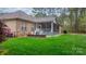 Beautiful backyard with a stone wall, lush green lawn, and a screened-in porch for outdoor enjoyment at 7268 Kiskadee Dr, Denver, NC 28037