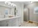 Bathroom featuring double sinks with grey cabinets and a glass walk-in shower at 7268 Kiskadee Dr, Denver, NC 28037