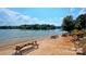 Sandy beach with picnic tables along a calm lake, perfect for relaxation and Gathering gatherings at 7268 Kiskadee Dr, Denver, NC 28037