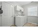 Well-lit laundry room with white cabinets, washer, and dryer with tiled floors at 7268 Kiskadee Dr, Denver, NC 28037