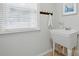 Bright laundry room with utility sink, window with blinds and convenient towel rack at 7268 Kiskadee Dr, Denver, NC 28037