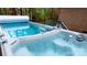Inviting swim spa with pristine, clear water, and a beverage tray for outdoor relaxation at 7268 Kiskadee Dr, Denver, NC 28037