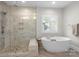 A luxurious bathroom with a free-standing tub and glass shower featuring tile walls at 7944 Park Rd, Charlotte, NC 28210