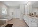 A bright bathroom features dual vanities, a freestanding tub, and a glass shower at 7944 Park Rd, Charlotte, NC 28210
