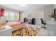 Bright bedroom featuring colorful accents, large windows, and a playful rug at 7944 Park Rd, Charlotte, NC 28210