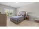 Comfortable bedroom with a wooden bed frame, neutral tones, and natural light at 7944 Park Rd, Charlotte, NC 28210