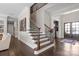 Elegant foyer showcases a staircase with wrought iron spindles, hardwood floors, and stylish decor, creating a grand entrance at 7944 Park Rd, Charlotte, NC 28210