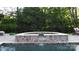 Close up of a hot tub with decorative tile work, integrated spillway and manicured greenery in the background at 7944 Park Rd, Charlotte, NC 28210
