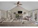 Bright living room featuring vaulted ceiling, ceiling fan, and a view of the backyard at 813 Deer Path Pl, Mooresville, NC 28115