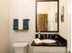 Half bathroom with black countertops, a modern mirror, and tile floors at 9514 Wheatfield Rd, Charlotte, NC 28277