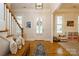 Inviting foyer with wood floors, staircase, bench, and a front door with decorative wreath at 9514 Wheatfield Rd, Charlotte, NC 28277