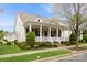 Inviting home showcasing a quaint front porch, lush landscaping, and timeless design elements at 9514 Wheatfield Rd, Charlotte, NC 28277