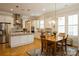Bright kitchen with island, stainless appliances, hardwood floors, and adjacent breakfast nook at 9514 Wheatfield Rd, Charlotte, NC 28277