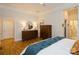 Bright main bedroom with wooden floors, dresser, armoire, and ensuite bathroom at 9514 Wheatfield Rd, Charlotte, NC 28277