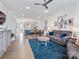 Open-concept living area with a view into the kitchen and dining room. Hardwood floors and modern decor at 9710 Ainslie Downs St, Charlotte, NC 28273