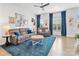 Comfortable living room with plush sofas, a ceiling fan, and large windows with blue curtains at 9710 Ainslie Downs St, Charlotte, NC 28273