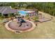 Aerial view of a community playground and pool area surrounded by trees at 9878 Verdun Ct, Fort Mill, SC 29707