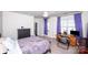 Relax in this light-filled bedroom with purple drapes, desk, ceiling fan, and plush carpet at 9878 Verdun Ct, Fort Mill, SC 29707
