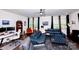 Contemporary living room with a blue sectional sofa, modern desk area, and hardwood floors at 9878 Verdun Ct, Fort Mill, SC 29707