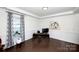 Bright home office with wainscoting, a large window with curtains, and hardwood floors for a professional workspace at 9878 Verdun Ct, Fort Mill, SC 29707