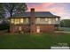 Charming two-story home with a brick foundation and well-lit windows at sunset at 109 Windmill Rd, Salisbury, NC 28147