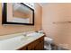 Bathroom with wood-grain walls, a single sink vanity and toilet with dark plank flooring at 109 Windmill Rd, Salisbury, NC 28147