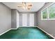 A bedroom featuring a ceiling fan, green carpet, and a large window with natural light at 109 Windmill Rd, Salisbury, NC 28147