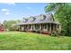 Charming home featuring a wide front porch with ample seating, lush lawn, and beautiful landscaping at 109 Windmill Rd, Salisbury, NC 28147