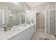 Bright bathroom boasts double vanity with marble countertop, modern fixtures, and glass shower at 1105 Reece Rd, Charlotte, NC 28209