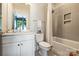 Modern bathroom with tiled shower and tub, marble-top vanity, and contemporary fixtures at 1105 Reece Rd, Charlotte, NC 28209