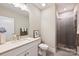 Modern bathroom with a sleek vanity, mirror, and walk-in shower featuring gray tile and glass door at 1105 Reece Rd, Charlotte, NC 28209