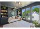 Bedroom featuring built-in storage, a comfortable couch, and scenic backyard views through large windows at 1105 Reece Rd, Charlotte, NC 28209