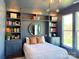 Comfortable bedroom with built-in bookshelves, stylish lighting, and large windows with backyard views at 1105 Reece Rd, Charlotte, NC 28209