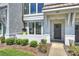 Inviting front porch with dark gray door, lush greenery, and exterior lighting at 1105 Reece Rd, Charlotte, NC 28209