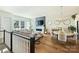 Open-concept living room and dining area with hardwood floors, fireplace, and large windows at 1105 Reece Rd, Charlotte, NC 28209