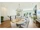 Open-concept living area with hardwood floors, fireplace, modern chandelier, and natural light from large windows at 1105 Reece Rd, Charlotte, NC 28209